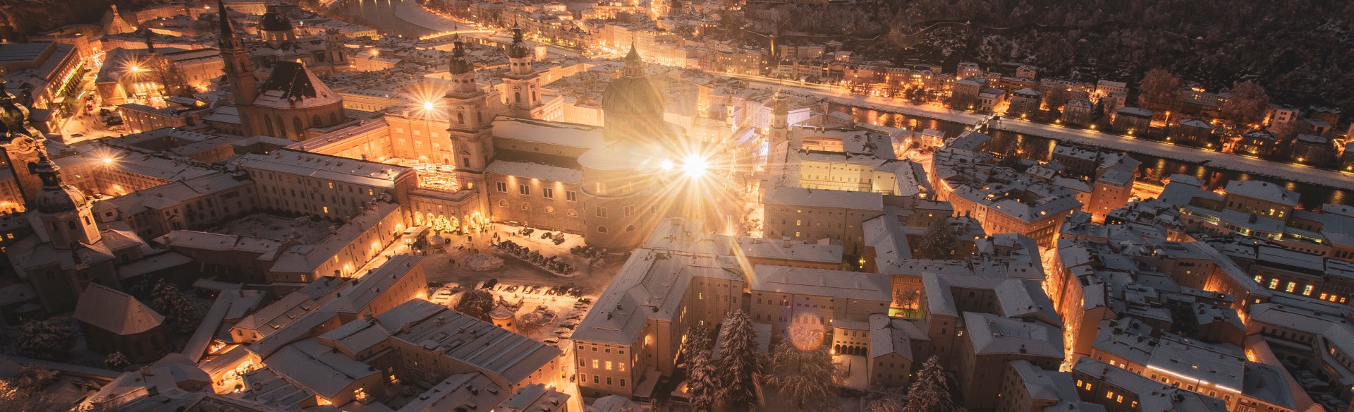 Blick auf die Stadt Salzburg, den Mönchsberg, Kapuzinerberg und festung Hohensalzburg bei Sonnenuntergang und in der Nacht im Winter, kurz vor Weihnachten 2023 im Salzburger Land, Österreich.