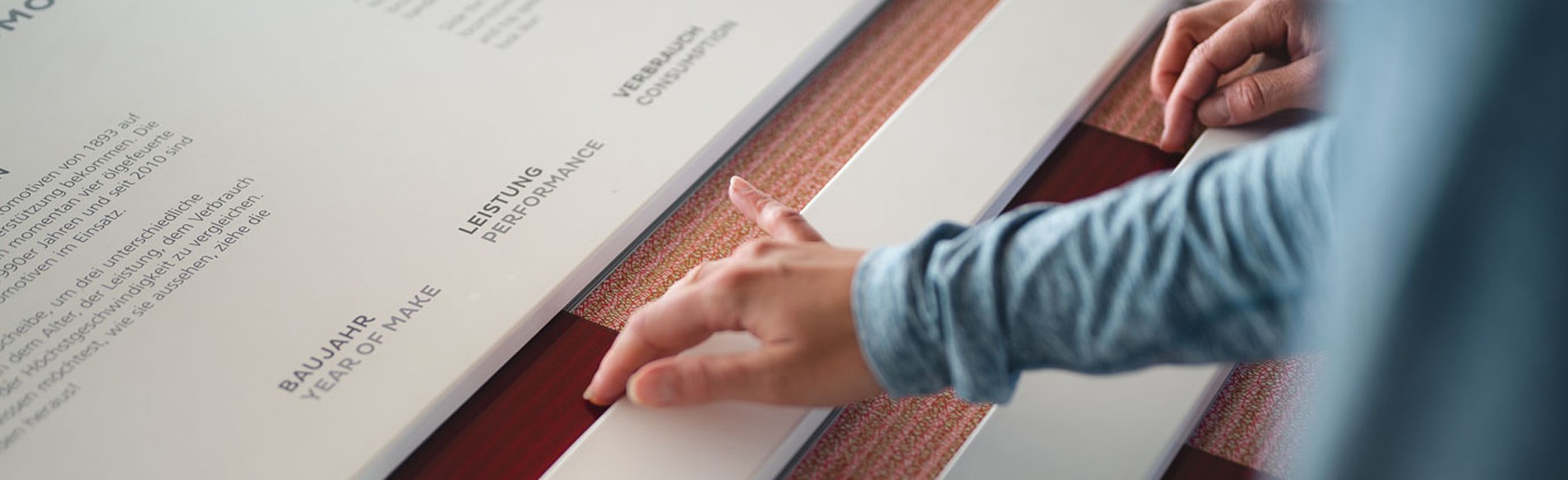 Nahaufnahme einer Hand von einer Person die sich eine Informationstafel ansieht