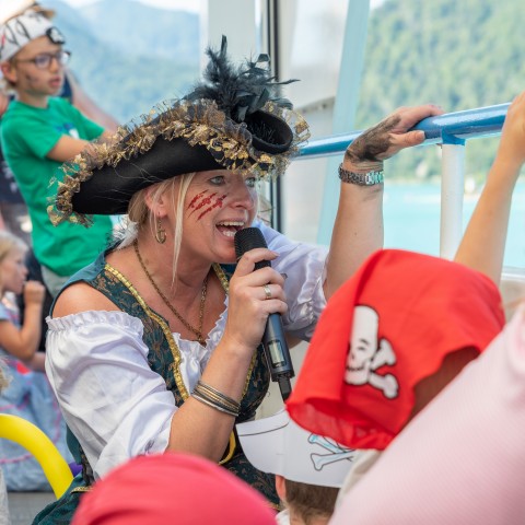EIne Frau als Piratin verkleidet bei einer Veranstaltung der WolfgangseeSchifffahrt mit Mikro in der Hand