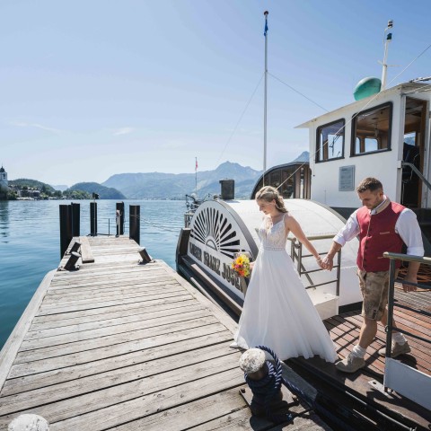 Hochzeitspaar verlässt nach der Hochzeit das Schiff der Wolfgangseeschiffahrt.