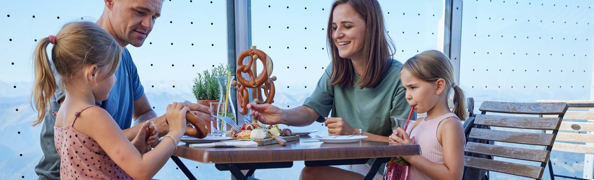 Eine Familie sitzt am Tisch auf der Terrasse der Himmelspforte am Schafberg