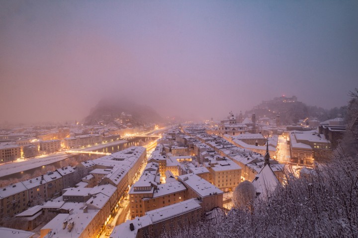 Blick auf ein schneebedecktes Salzburg im Advent vom Ausichtspunkt des MönchsbergAufzuges