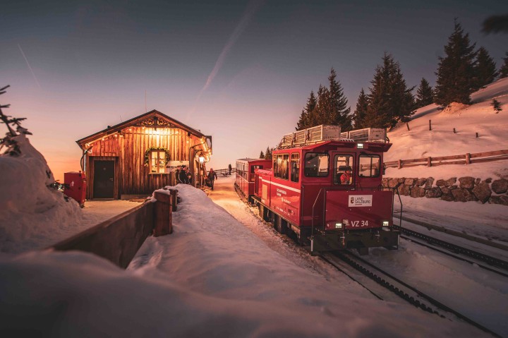 Die Schafbergalm mit der Weihnachtslok der SchafbergBahn in einer Schneelandschaft