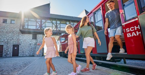 Eine Familie steigt am Gipfel aus der SchafbergBahn aus. 