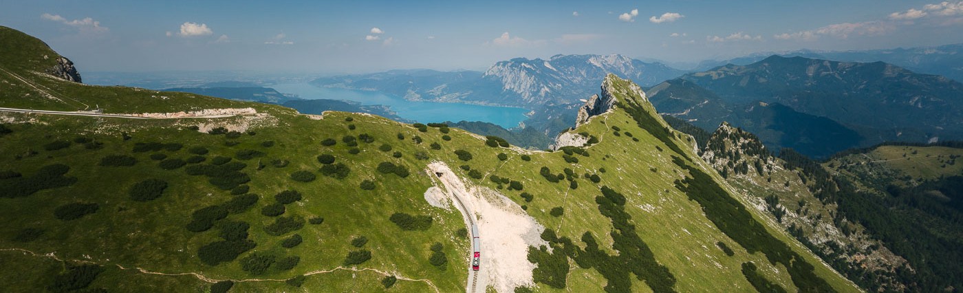 Drohnenaufnahme des Schafbergs, die SchafbergBahn fährt auf den Gipfel. 